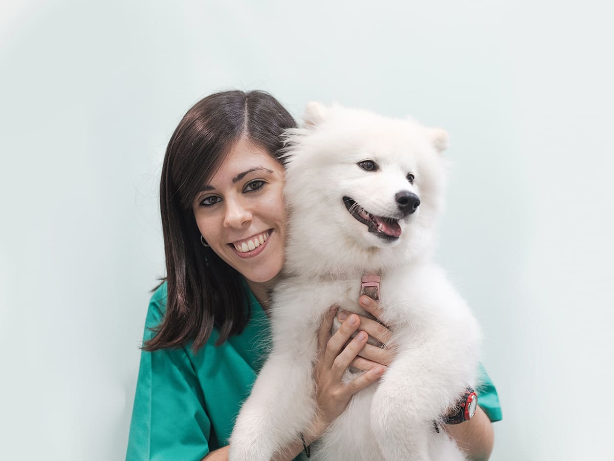 Veterinaria abraza a perro en Hospital Veterinario Riera Alta Barcelona